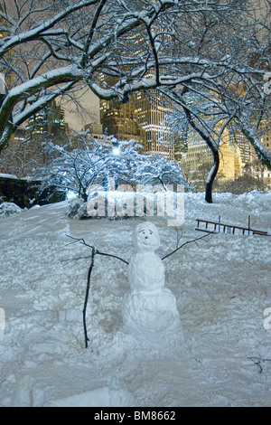 Un bonhomme de neige près de Gapstow Bridge à l'extrémité sud de la ville de New York's Central Park de nuit après une tempête. Banque D'Images