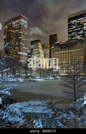 Manhattan skyline, comme la Plaza Hotel & GM Building at night vu de Gapstow Bridge dans Central Park après une tempête Banque D'Images