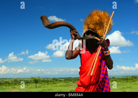 Guerrier Masai traditionnelles jouant la corne. L'Afrique. Au Kenya. Le Masai Mara Banque D'Images