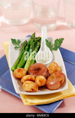 Les pommes de terre et navets confits avec les asperges. Recette disponible. Banque D'Images