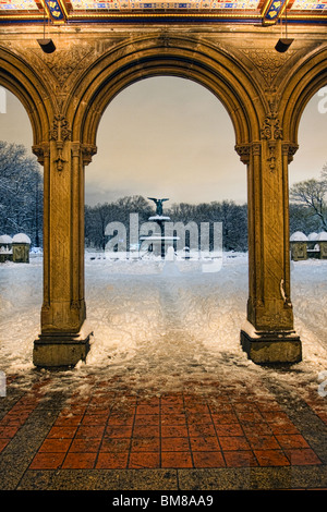 Fontaine Bethesda à New York City's Central Park vu à travers les arches de Bethesda terrace on a snowy winter's night. Banque D'Images