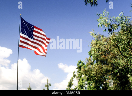 Drapeau américain va à brise vent sur mât contre ciel bleu avec des nuages nation gouvernement patriote du pays d'antan Banque D'Images