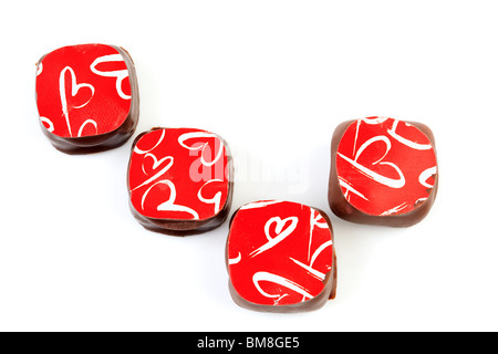 Quatre bonbons de chocolat noir isolé sur fond blanc Banque D'Images