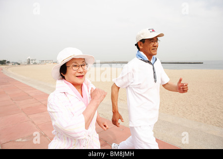 Senior couple jogging on beach Banque D'Images