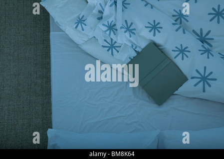 Open book lying face vers le bas sur le lit vide Banque D'Images