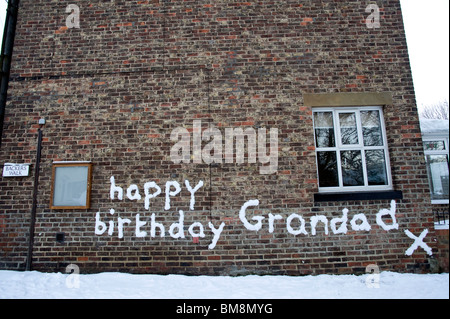 Joyeux anniversaire papi message écrit dans la neige sur le mur en grand broughton North Yorkshire Banque D'Images