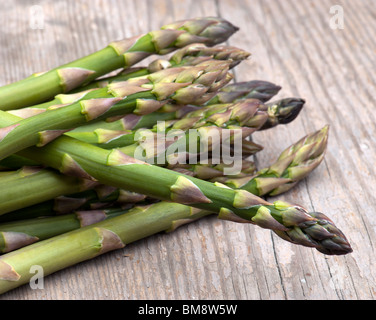 Asperges fraîches posées sur une table de cuisine en bois Banque D'Images