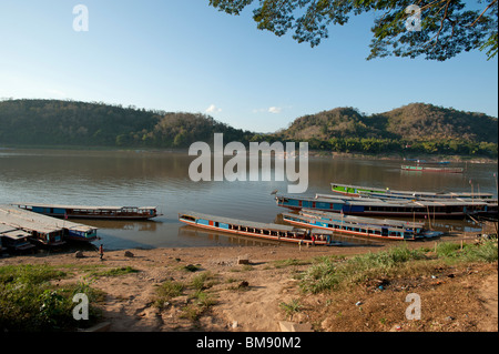 Lent en bois bateaux amarrés sur les rives du Mékong à Luang Prabang au Laos Banque D'Images