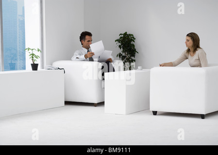 Collègues assis ensemble dans office, l'homme à examiner des documents Banque D'Images
