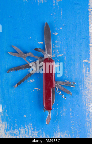 Ancien couteau suisse sur un fond de bois bleu texturé Banque D'Images