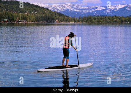 Une pagaie boarder traverse le lac Donner, Truckee, Californie Banque D'Images