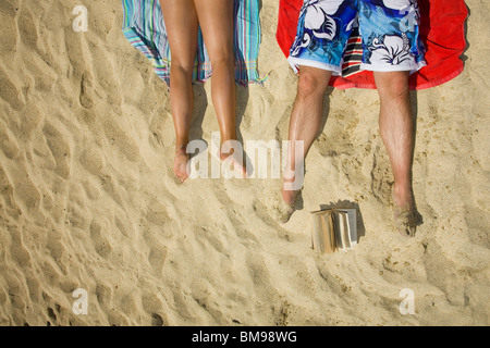 Un couple sur le sable du dessus avec un livre Banque D'Images