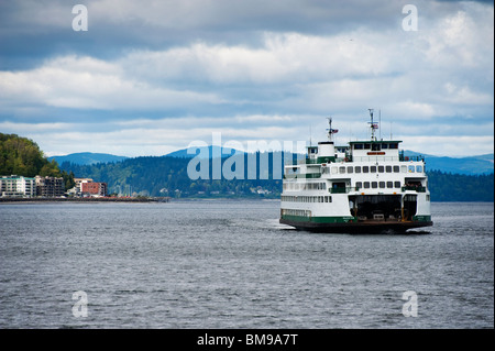 La Washington State Ferry bateau navigue dans l'Elliott Bay le long du front de mer de Seattle. West Seattle en arrière-plan Banque D'Images