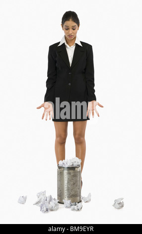 Businesswoman standing in front of une corbeille à papier et des gestes Banque D'Images