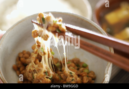 Le natto de mélange avec des baguettes Banque D'Images