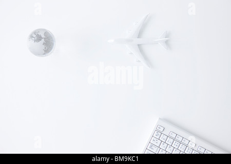 Clavier d'ordinateur, Globe and toy airplane on white background Banque D'Images