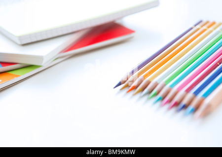 Des crayons et blocs-notes on white background, Close up Banque D'Images