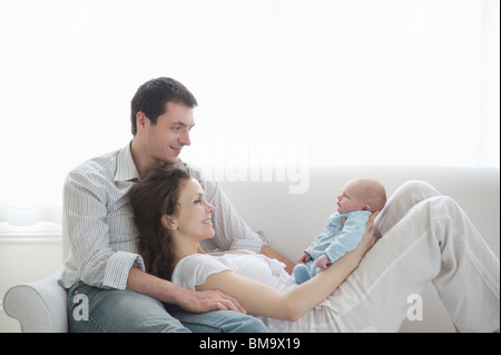 Famille de trois sur canapé avec deux semaines de bébé nouveau-né Banque D'Images