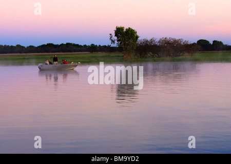 Bateau sur l'eau jaune billabong à l'aube. Le Kakadu National Park Banque D'Images