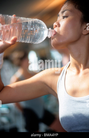Asian woman boit de l'eau au cours de ses exercices comme sport. Banque D'Images