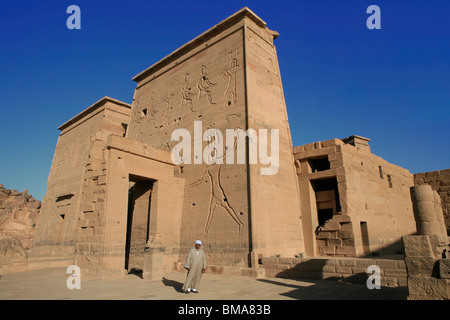 L'Homme égyptien en costumes traditionnels en dehors du Premier pylône du Temple d'Isis à Philae, bon maintenant sur l'Île Agilka en Egypte Banque D'Images