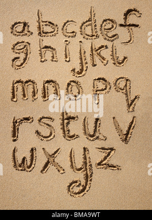 L'alphabet écrit dans le sable sur une plage. Banque D'Images