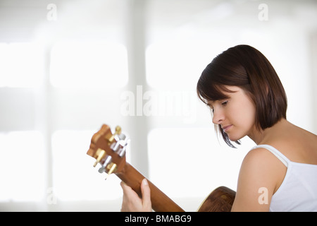 Femme assise avec guitare acoustique Banque D'Images