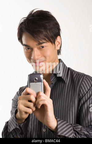 Man Taking Photograph with Mobile Phone Banque D'Images