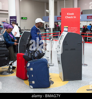 Les personnes qui utilisent l'auto ticket dans la machine au terminal sud des départs internationaux l'aéroport de Gatwick, England UK Banque D'Images