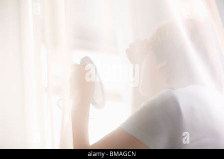 Femme mature ressemble à la réflexion dans un miroir à main Banque D'Images