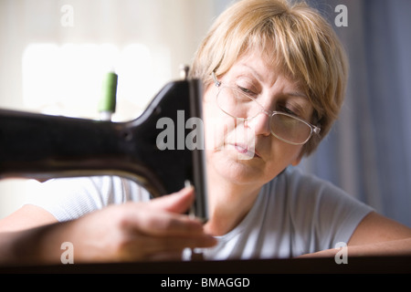 Femme mature règle pied de machine à coudre Banque D'Images