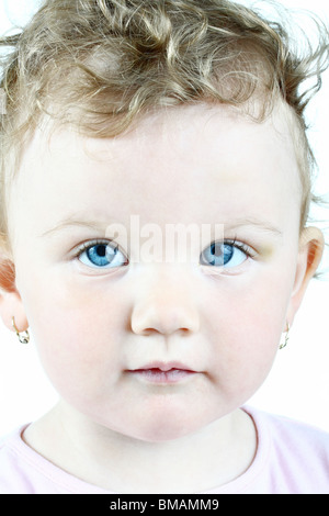 Portrait d'une petite fille aux yeux bleus, high key, isolated on white Banque D'Images