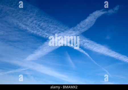 Des stries ou Jet Jet d'eau à partir d'aéronefs forment une croix dans le ciel au-dessus de Brighton & Hove, Sussex Banque D'Images