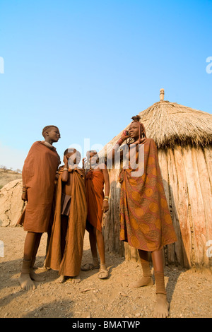 Les jeunes filles de la tribu Himba à à un téléphone cellulaire, Opuwo, Namibie Banque D'Images