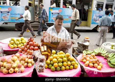 Vendeur de fruits lecture journal sur rue ; Calcutta Kolkata maintenant ; l'ouest du Bengale en Inde ; Banque D'Images