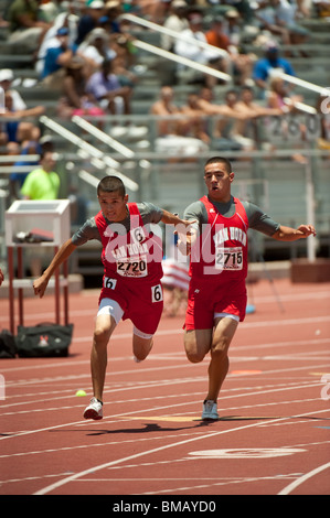 Homme runner hands off baton de coéquipier au cours de course de relais au Texas high school championnat de l'état d'athlétisme à Austin Banque D'Images