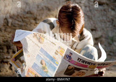 La lecture de l'homme rural journal de langue hindi l'alphabétisation dans le village urbain semi ; Dilwara Udaipur Rajasthan ; Inde ; Banque D'Images