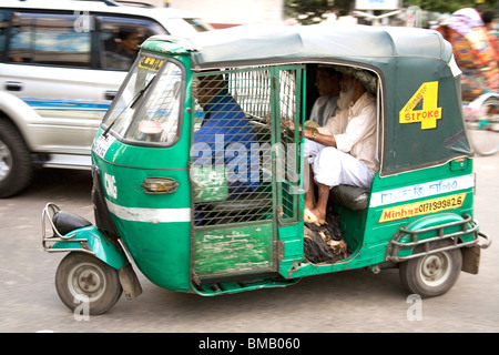 Scène de rue ; les passagers assis en vert auto rickshaw ; Dhaka Bangladesh ; Banque D'Images