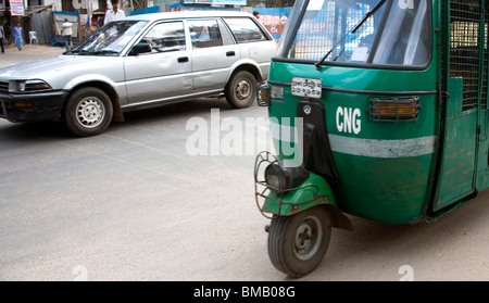 Scène de rue ; verte auto rickshaw le tempo et sur la circulation automobile à Dhaka au Bangladesh ; Banque D'Images