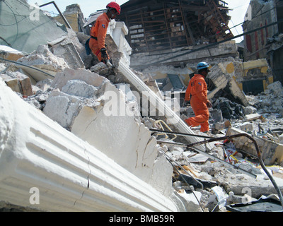 Les membres de la République dominicaine Defensa Civil chercher des survivants sous les décombres à Port-au-Prince après le séisme en Haïti Banque D'Images