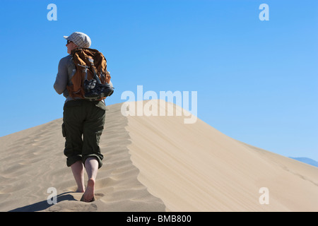 Female hiker walking in Mesquite Flat Dunes, Death Valley National Park, California, USA Banque D'Images