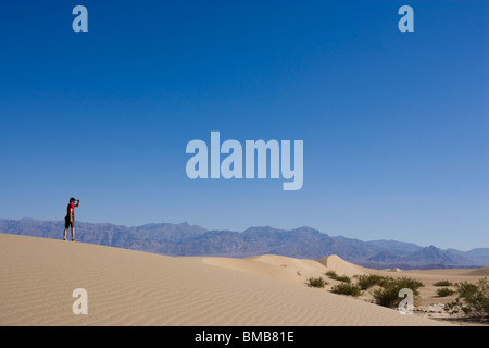 Male hiker looking out de Mesquite Flat Dunes, Death Valley National Park, California, USA Banque D'Images