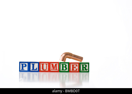 Enfants colorés blocks spelling plombier avec les raccords de tuyauterie en cuivre Banque D'Images