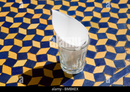 Verre d'eau et une serviette sur la table en mosaïque , Marrakech , Maroc , Afrique du Nord Banque D'Images