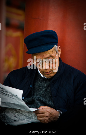 Vieil homme lisant le journal dans la Cité interdite à Pékin, Chine Banque D'Images