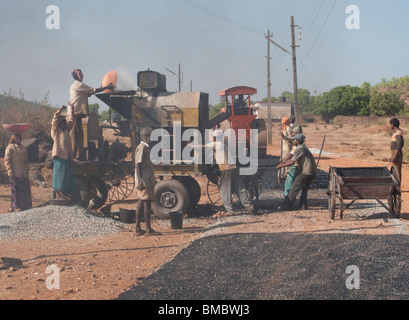 Les gens font une nouvelle route bitumée en Inde Banque D'Images