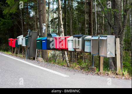 Rangée de boîtes mail le long d'une route goudronnée Banque D'Images