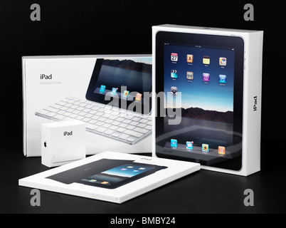 Apple iPad et accessoires d'emballage du produit et en boîte enveloppée dans du plastique. Isolé sur fond noir. Banque D'Images