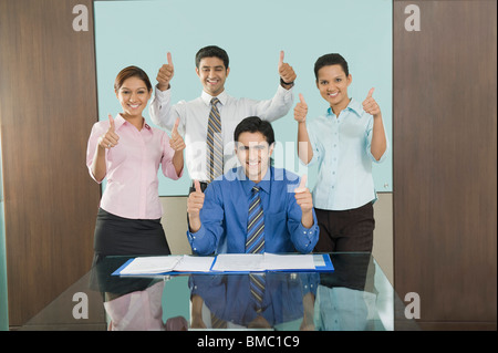Les dirigeants d'showing Thumbs up signe dans un bureau Banque D'Images
