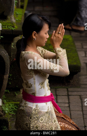 Une femme à Bali, en Indonésie, vient à la marché d'Ubud temple pour pratiquer sa foi hindoue sur le jour saint de Galungan. Banque D'Images